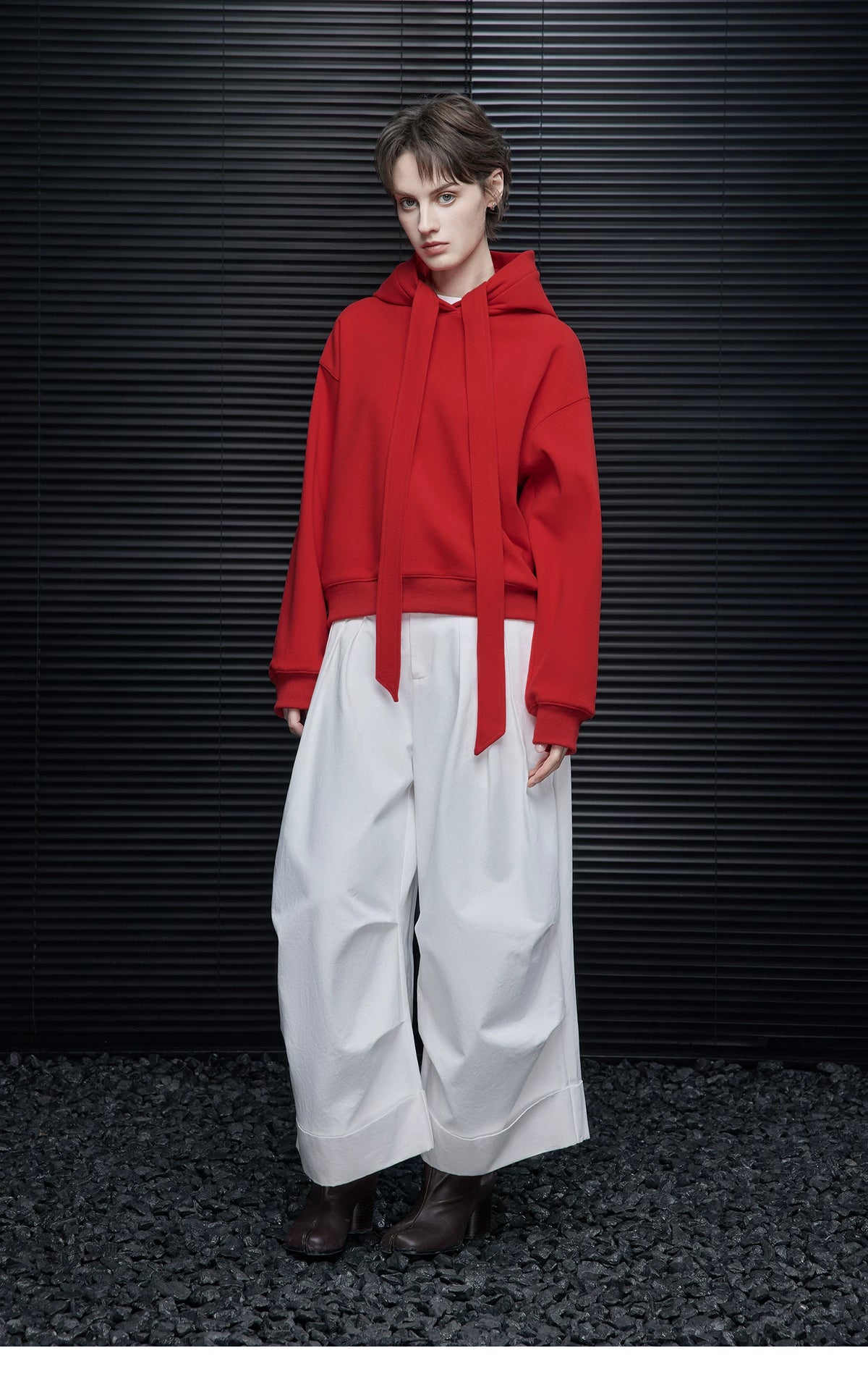 Full-length front view of Scarlet Red hoodie with neck ribbons hanging loose, styled with white wide-leg pants