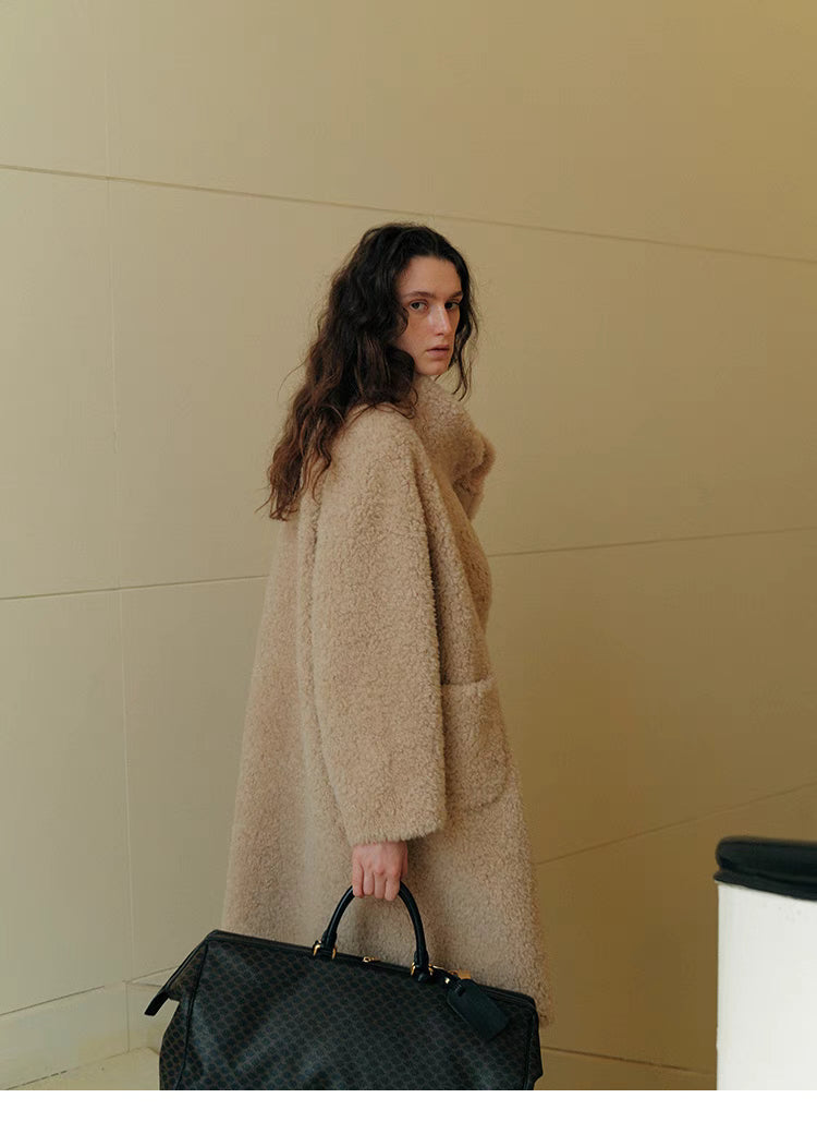 Back angled view of Sierra Luxe Shearling Coat in beige apricot showcasing clean straight silhouette, soft wool texture, and elegant drape