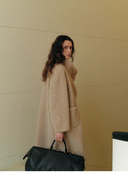 Back angled view of Sierra Luxe Shearling Coat in beige apricot showcasing clean straight silhouette, soft wool texture, and elegant drape