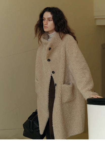 Front relaxed standing view of Sierra Luxe Shearling Coat in beige apricot showing mid-length cut, button closure, and soft textured finish