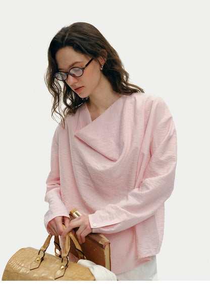 Pink silk cowl neck top styled with woven bag, front angled view