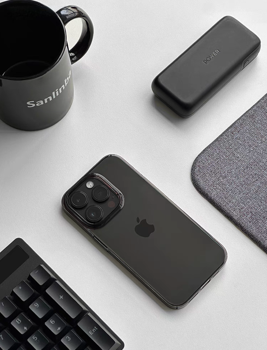 Clear black transparent phone case on iPhone placed on desk with keyboard mug and accessories lifestyle scene