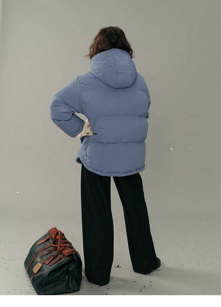 Back view of the dusty blue detachable-hood puffer jacket showing hood and quilted texture.