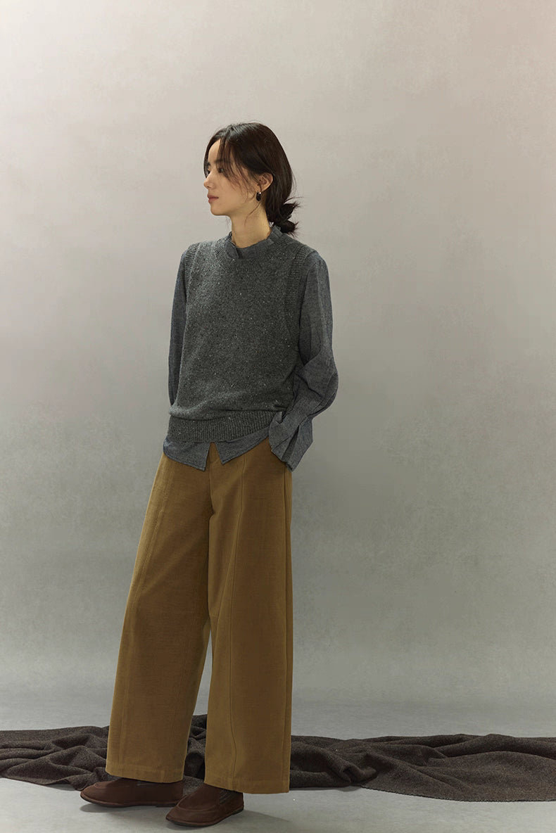 Full-body side outfit featuring speckled knit vest with wide-leg pants and dark shoes.