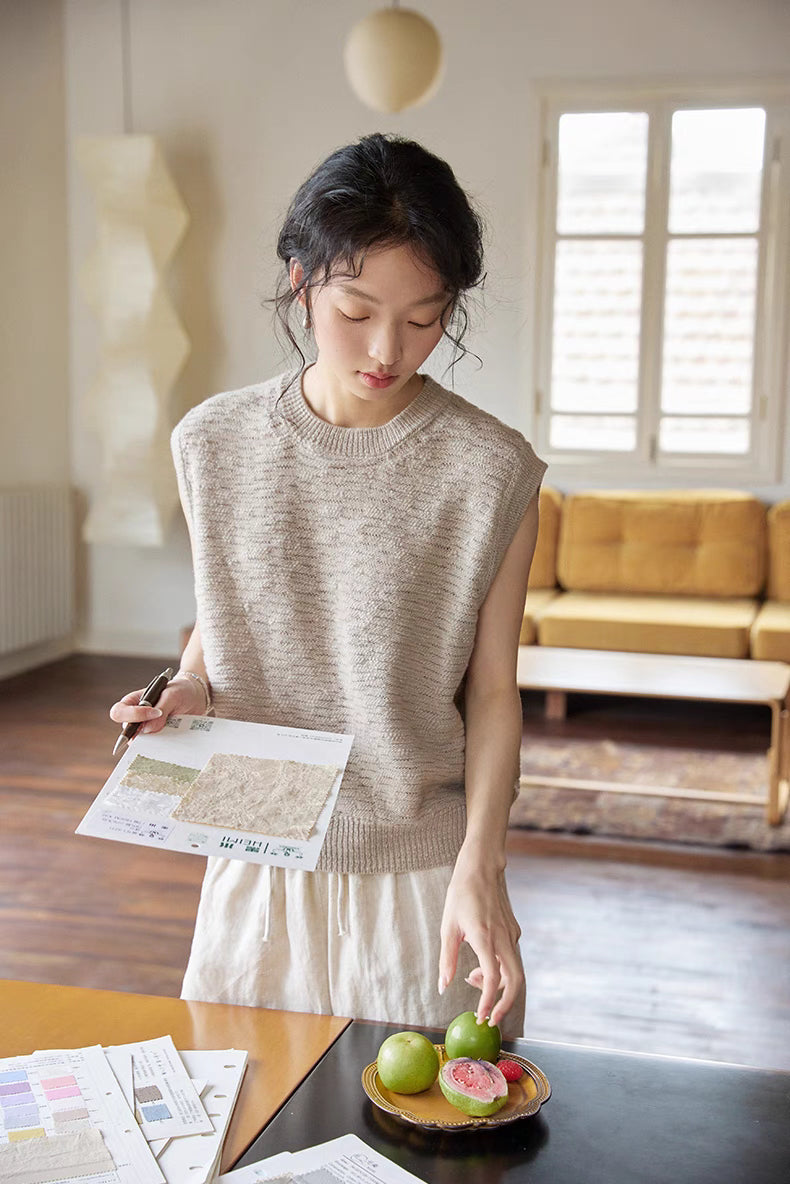 Model wearing Cream Gray merino knit vest in close-up view, showcasing soft texture, cap sleeves, and subtle natural tone