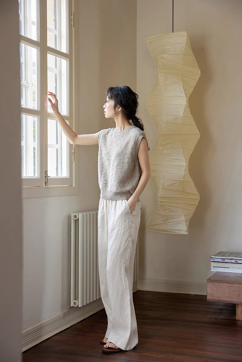 Side view of Cream Gray merino knit vest near window in natural light, showing airy structure, soft knit texture, and effortless minimal style