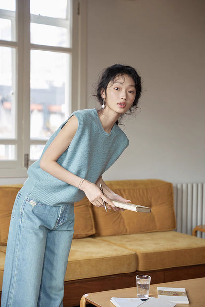 Lake Blue textured knit vest styled in indoor setting with model leaning forward, highlighting breathable merino fabric and casual everyday styling