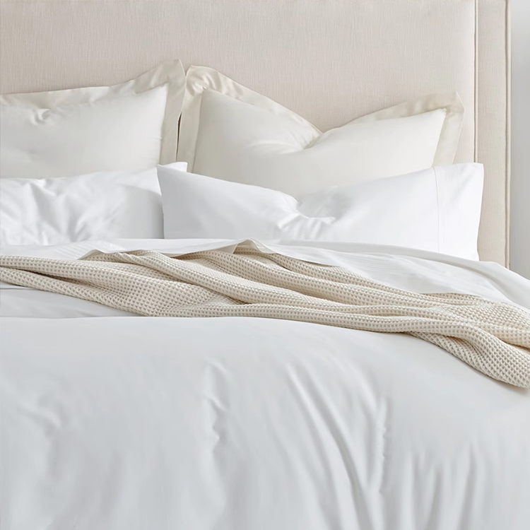Khaki waffle gauze cotton blanket layered across white bedding creating a calm minimalist bedroom aesthetic.
