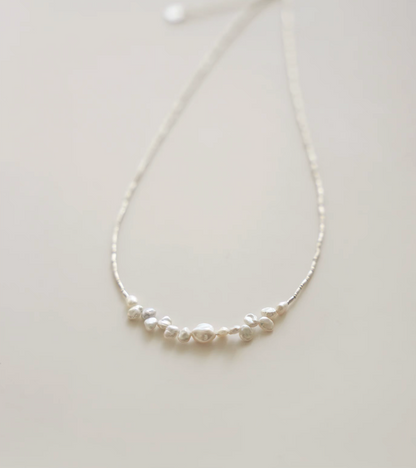 Close-up of soft white baroque pearl silver choker highlighting natural irregular pearl shapes and texture