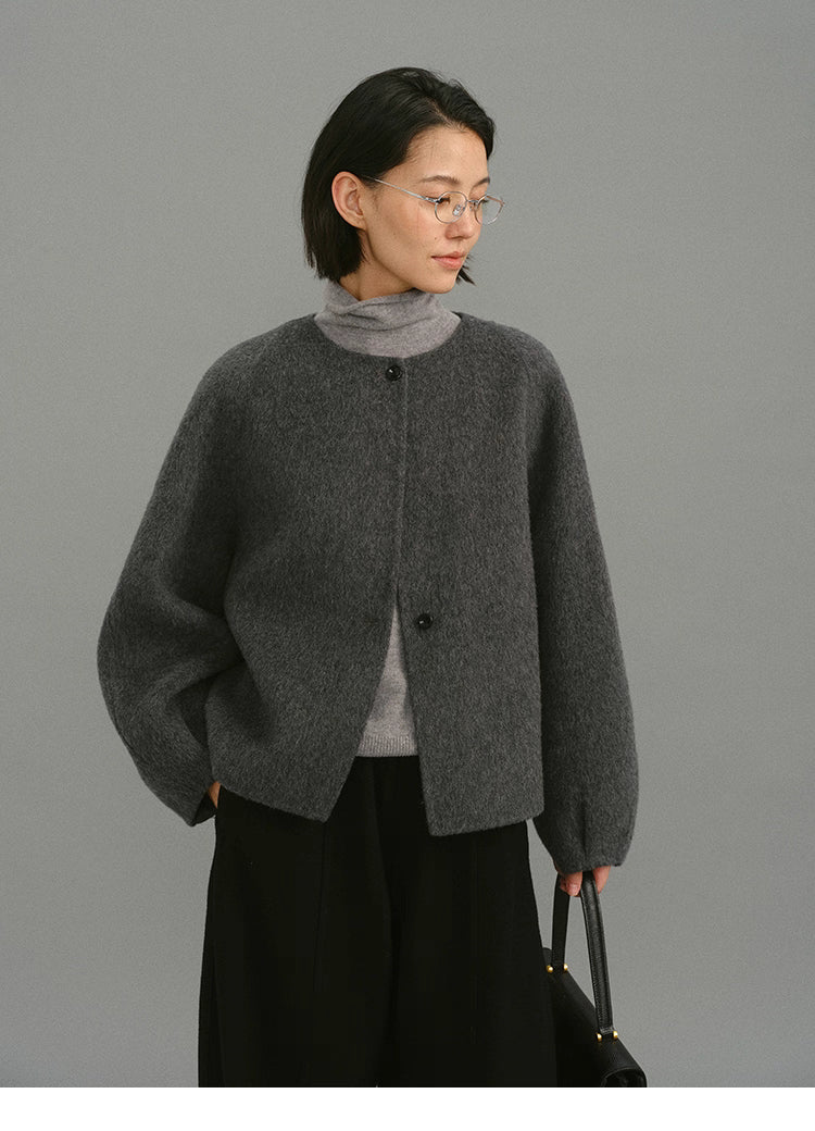 Model wearing charcoal cocoon jacket with relaxed fit and hands in pockets