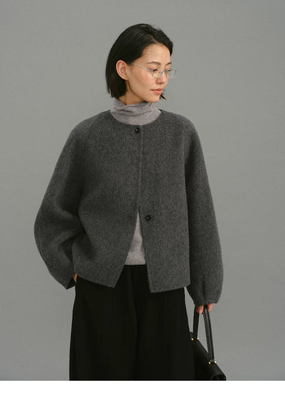 Model wearing charcoal cocoon jacket with relaxed fit and hands in pockets