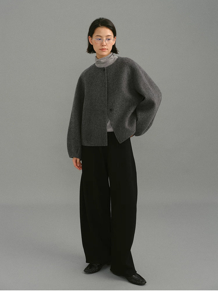 Full-body shot of charcoal soft-wool cocoon jacket styled with black wide-leg pants