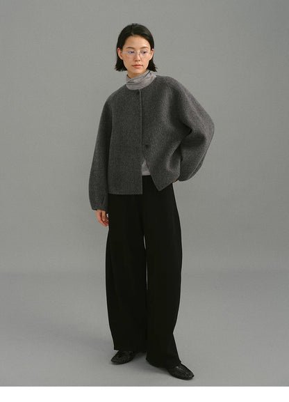 Full-body shot of charcoal soft-wool cocoon jacket styled with black wide-leg pants