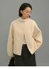 Front view of woman wearing cream soft-wool cocoon jacket with round-neck design