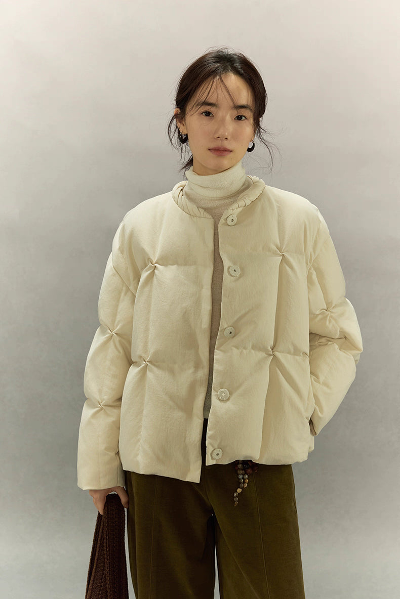 Cream beige SoftCloud lightweight down jacket, front half-body view with model wearing turtleneck and olive pants.