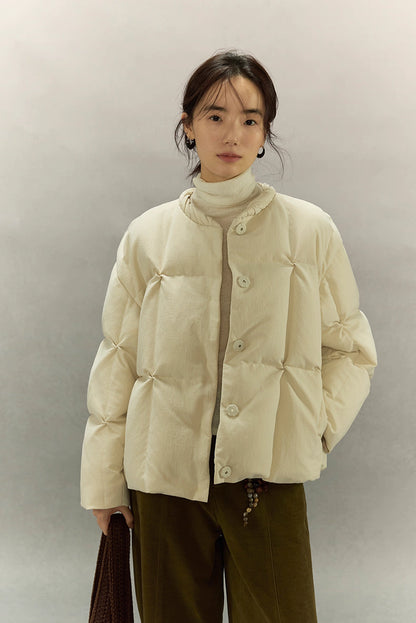 Cream beige SoftCloud lightweight down jacket, front half-body view with model wearing turtleneck and olive pants.