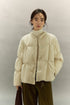 Cream beige SoftCloud lightweight down jacket, front half-body view with model wearing turtleneck and olive pants.
