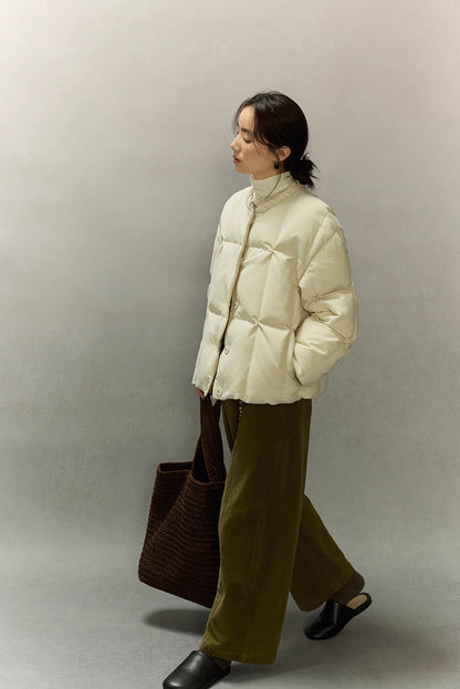Side profile of model walking in cream beige SoftCloud down jacket, showing short length and easy movement.