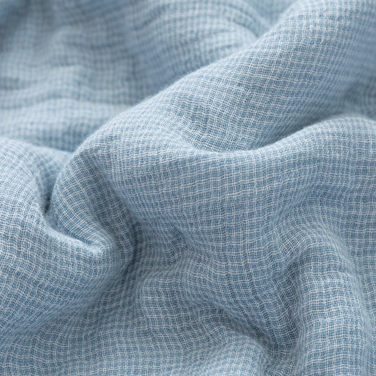 Close-up of Light Blue SoftNest cotton muslin fabric showing breathable triple-layer woven muslin texture