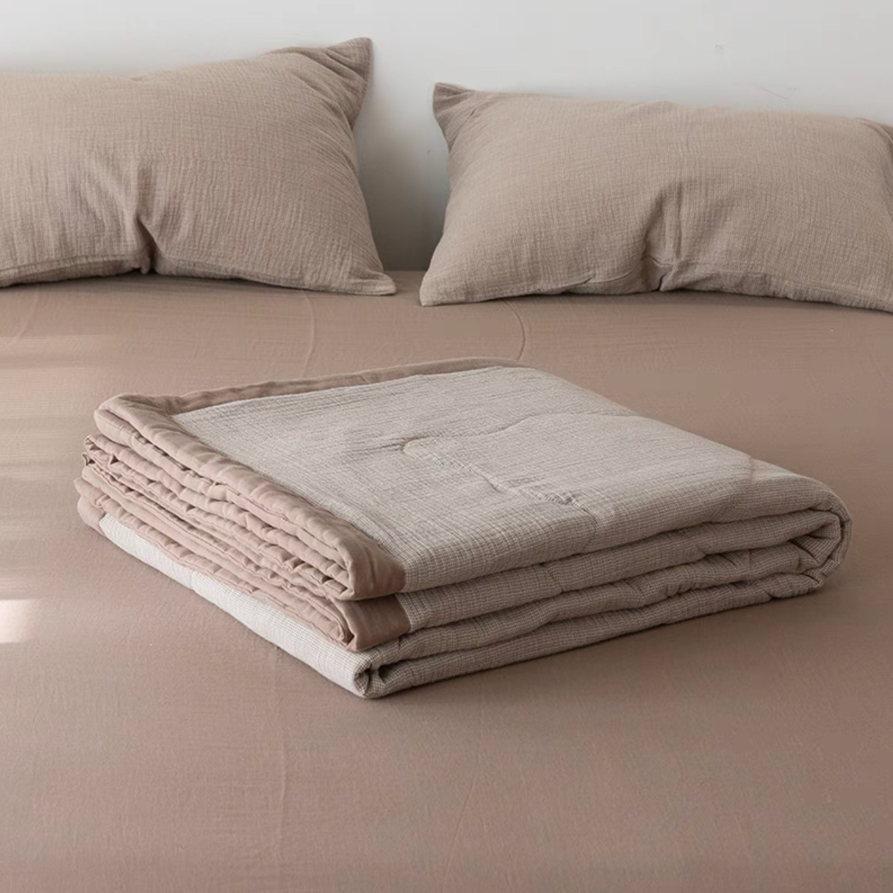 Folded Coffee color SoftNest cotton muslin quilt highlighting breathable triple-layer muslin texture