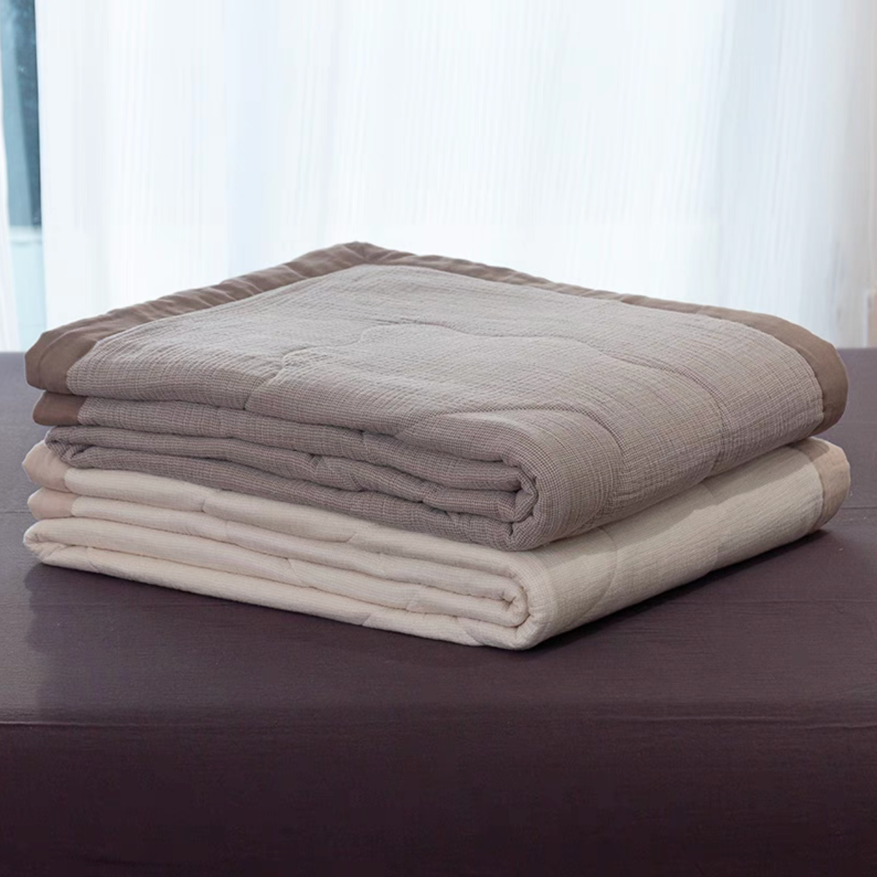 Stacked SoftNest cotton muslin quilts in Coffee color showing soft lightweight layered construction