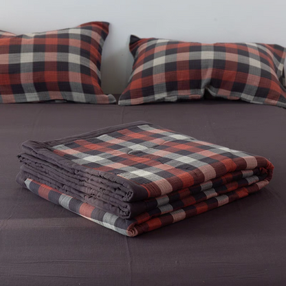 Folded Red Black Stripes SoftNest cotton muslin quilt placed on bed highlighting soft breathable muslin layers
