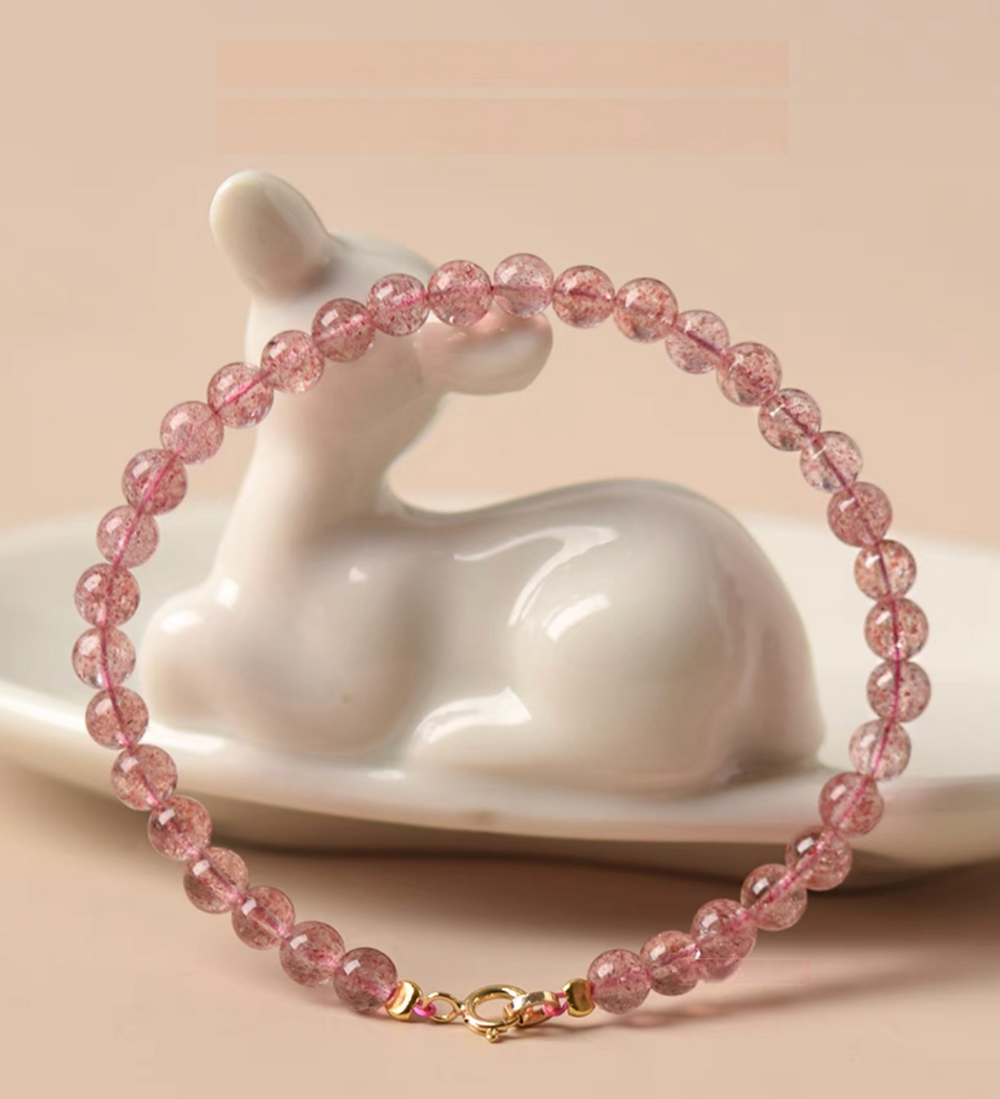 Pink strawberry quartz bracelet wrapped around ceramic decor showing full circular shape