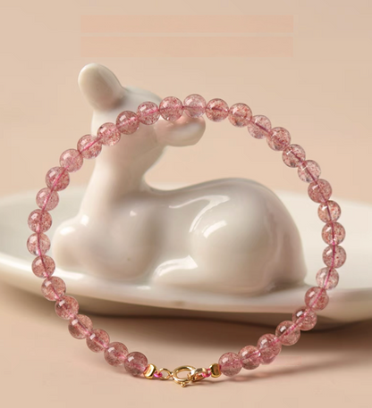 Pink strawberry quartz bracelet wrapped around ceramic decor showing full circular shape