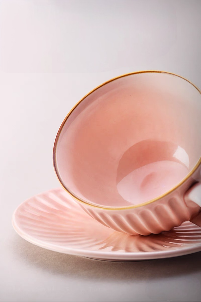 Close-up of pink striped ceramic cappuccino cup interior and saucer showing smooth glossy glaze and curved shape