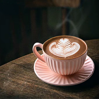 Pink striped ceramic cappuccino cup and saucer with latte art placed on wooden surface in cozy lifestyle scene