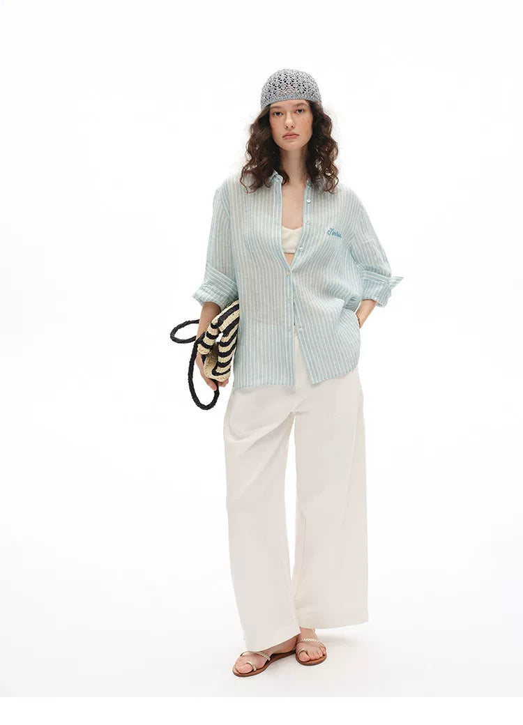 Full outfit view of blue striped linen shirt styled with wide-leg trousers