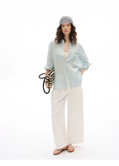 Full outfit view of blue striped linen shirt styled with wide-leg trousers
