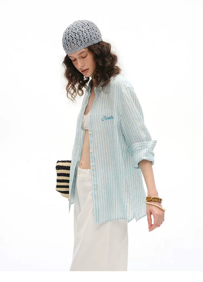 Side profile of blue striped linen shirt with "Timeless" embroidered detail
