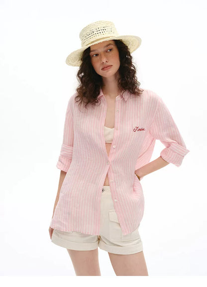 Front view of pink striped linen shirt with straw boater hat