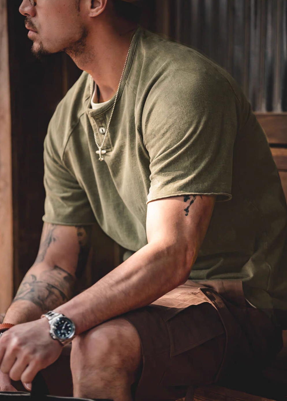 Style Washed Henley T-Shirt Green side sitting lifestyle view showing soft washed texture short sleeves and casual relaxed styling