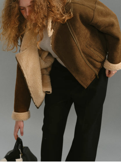 Model bending down wearing caramel brown suede shearling jacket.