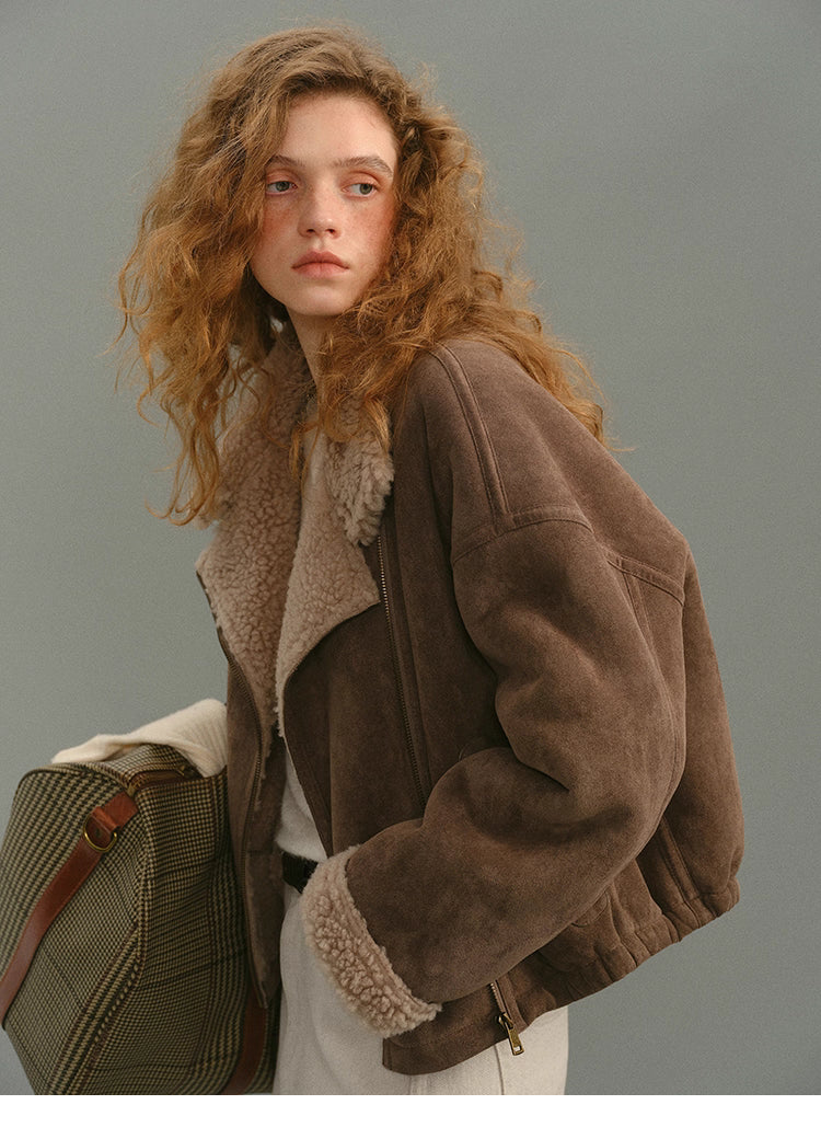 Side view of mocha suede shearling jacket paired with travel bag.