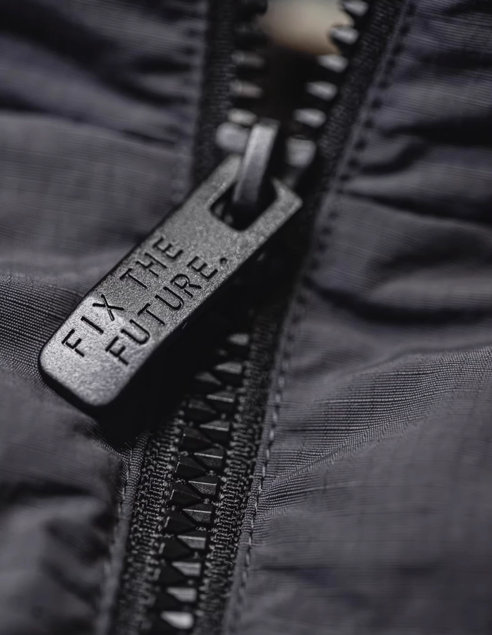 Macro view of SummitShield down jacket zipper hardware showing durable construction and high-quality fastening detail
