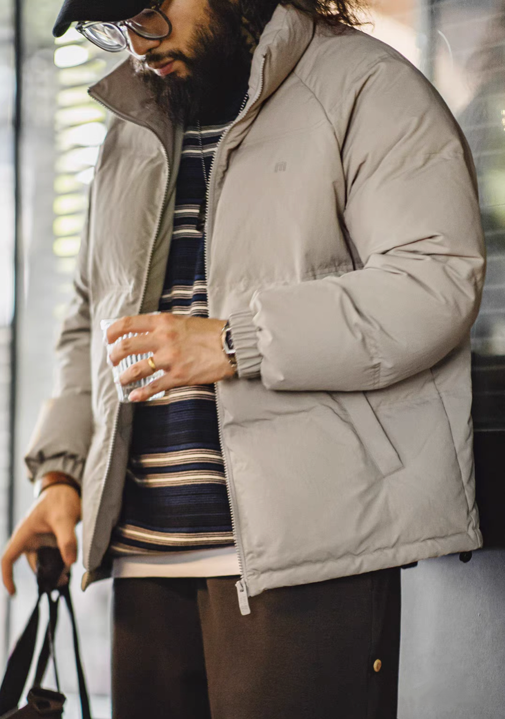 Men wearing light gray SummitShield down jacket in urban setting, showcasing lightweight warmth, stand collar design, and modern street-style layering