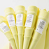 Close-up of lemon yellow cotton tee care labels showing fabric and size details