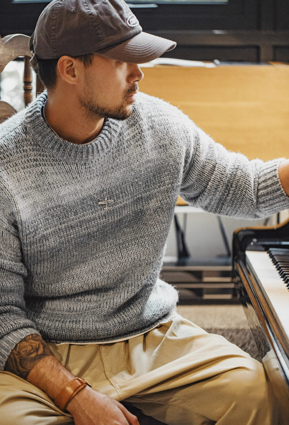 Man sitting wearing Sunset Drift Knit Sweater in Lead Grey highlighting cozy ombré knit fabric casual styling and everyday comfort