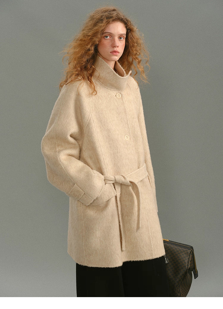 Front view of the SuriBlend oatmeal wrap coat with stand collar and belt tied loosely.