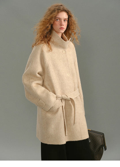 Front view of the SuriBlend oatmeal wrap coat with stand collar and belt tied loosely.