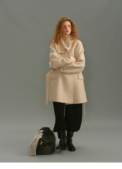 Full-body front look of the wrap coat styled with black trousers and winter boots.