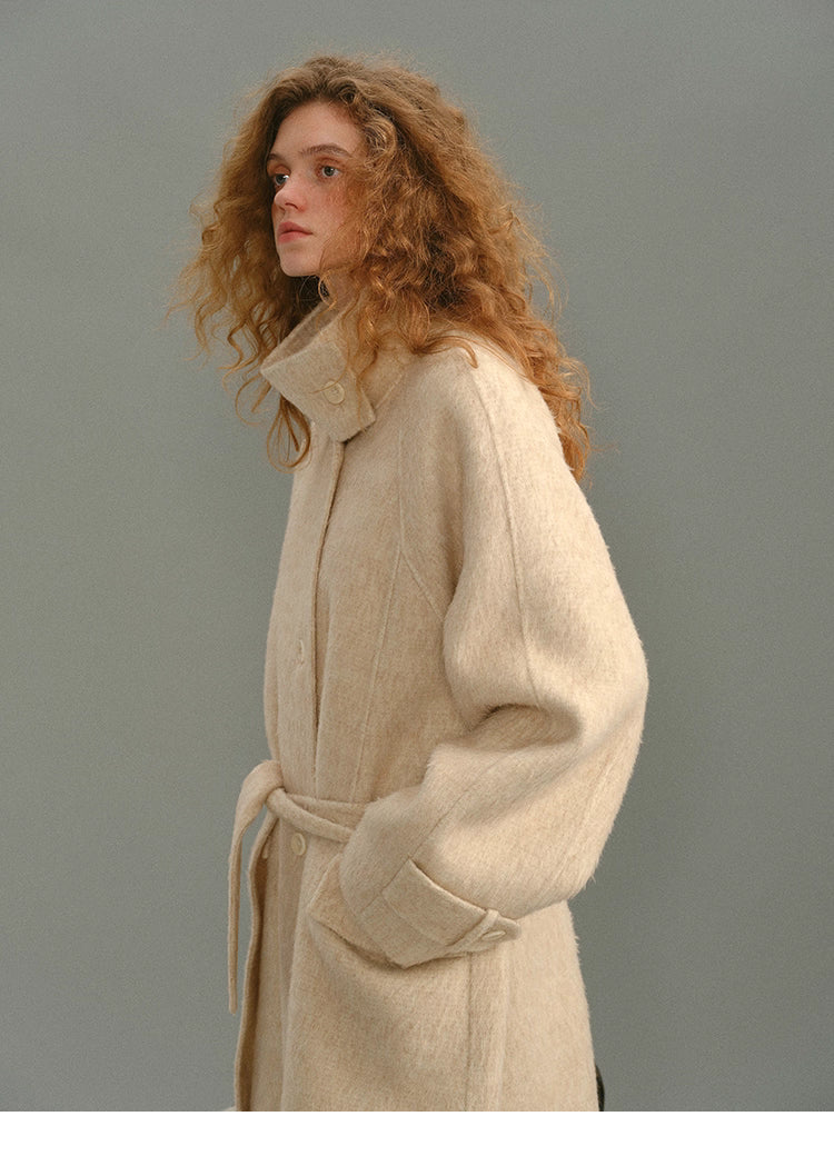 Side profile of the SuriBlend wrap coat highlighting collar structure and sleeve shape.