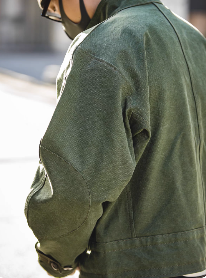 Back view of Swedish military motorcycle jacket worn by model – rugged green canvas with structured fit.