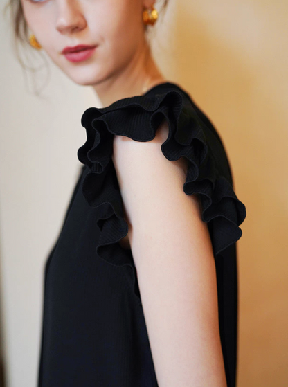 Detailed view of black top double-layer ruffle sleeves showing textured edge and feminine design
