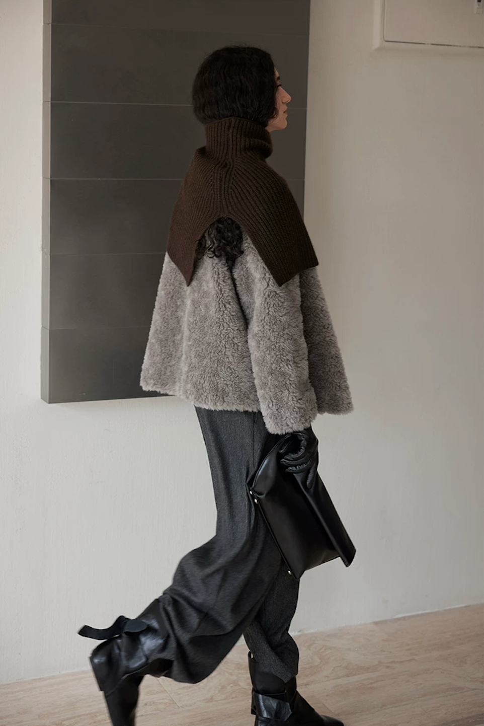 Side view of a Taupe Gray hip-length wool teddy jacket in motion