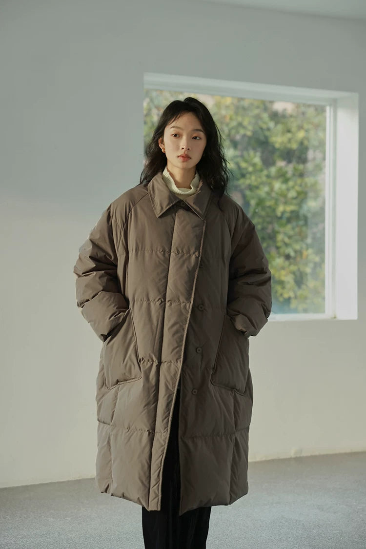 Front view of a Taupe below-the-knee down coat buttoned, with two large patch pockets