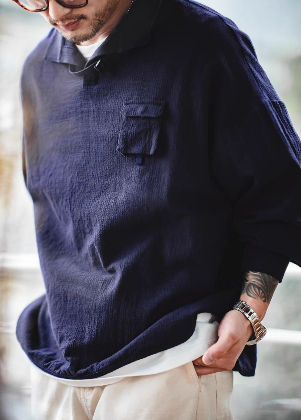 Blue textured cotton polo shirt close-up view highlighting jacquard weave texture and flap chest pocket detail